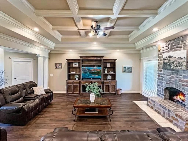 living room featuring a ceiling fan, coffered ceiling, dark wood finished floors, a fireplace, and ornamental molding