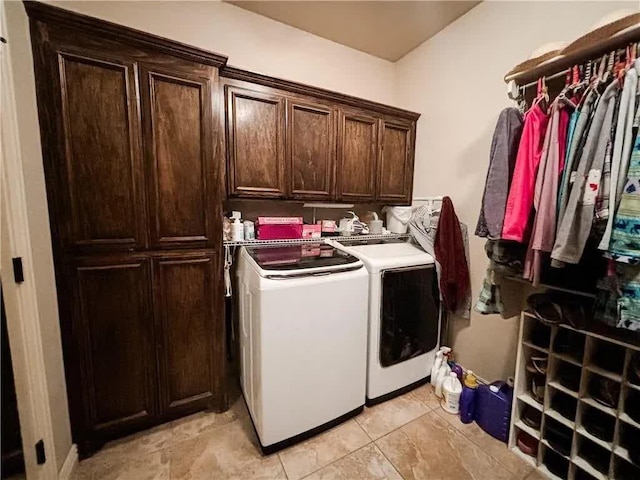 clothes washing area featuring cabinet space and separate washer and dryer