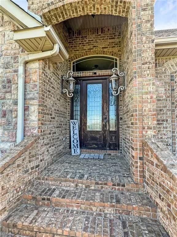 view of exterior entry featuring brick siding