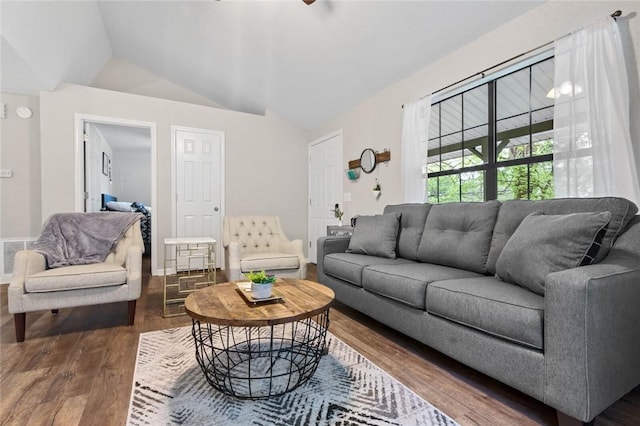 living area featuring visible vents, wood finished floors, and vaulted ceiling