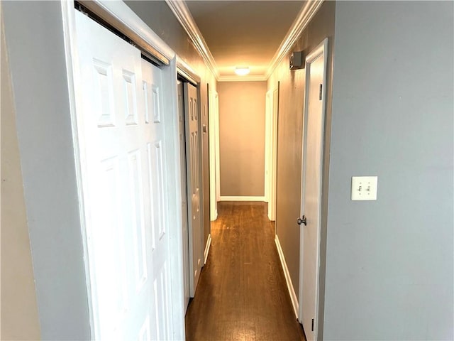 corridor featuring dark wood-style floors, baseboards, and ornamental molding