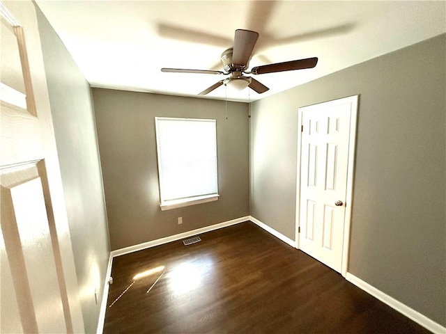 unfurnished room featuring visible vents, a ceiling fan, baseboards, and wood finished floors