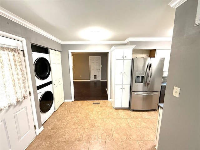 interior space featuring laundry area, baseboards, stacked washer and clothes dryer, and ornamental molding