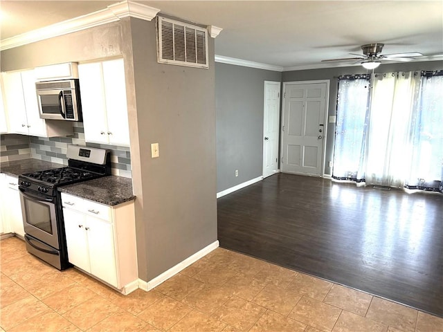 kitchen featuring visible vents, backsplash, crown molding, baseboards, and stainless steel appliances