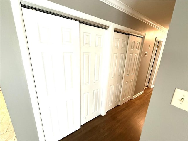 hall featuring crown molding and dark wood-type flooring