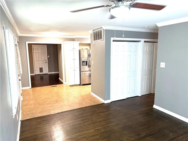 interior space with visible vents, ornamental molding, baseboards, and wood finished floors