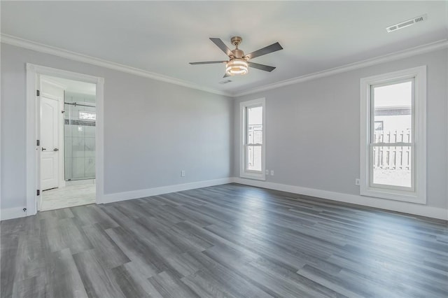 empty room with dark wood finished floors, a ceiling fan, visible vents, and ornamental molding