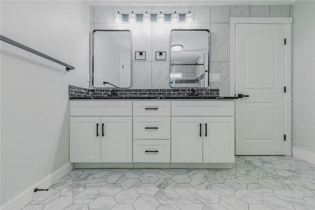 bathroom with a tile shower, a sink, marble finish floor, and double vanity