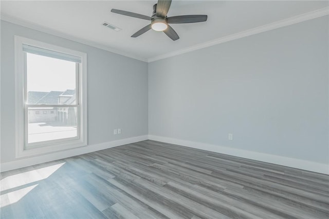 spare room with visible vents, crown molding, ceiling fan, baseboards, and wood finished floors