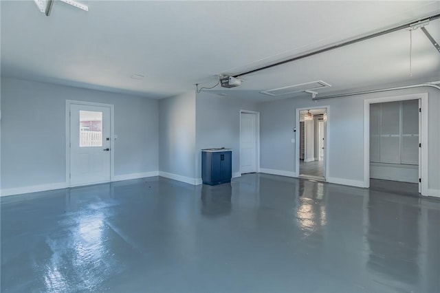 garage featuring a garage door opener and baseboards