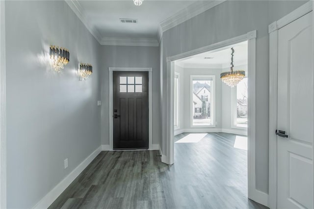 entrance foyer featuring dark wood-style floors, baseboards, visible vents, an inviting chandelier, and ornamental molding