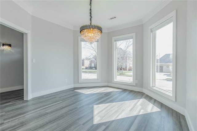 unfurnished dining area with visible vents, baseboards, ornamental molding, wood finished floors, and a notable chandelier