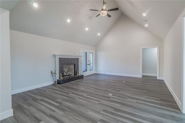 unfurnished living room featuring wood finished floors, baseboards, high vaulted ceiling, a fireplace, and ceiling fan