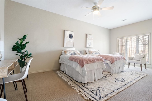 carpeted bedroom with visible vents, a ceiling fan, and baseboards