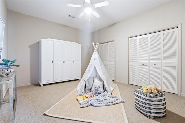 rec room featuring light carpet, visible vents, a ceiling fan, and baseboards