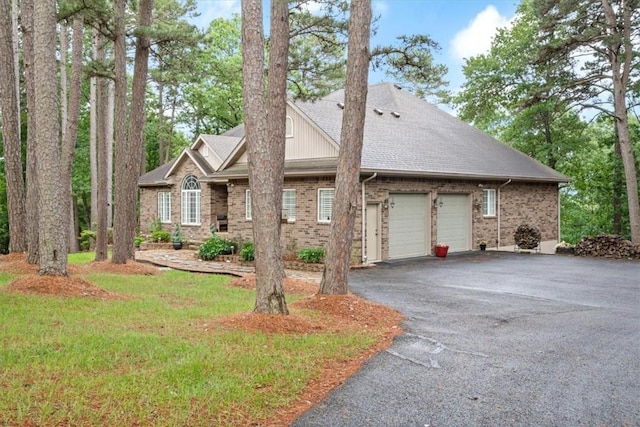 view of front facade featuring aphalt driveway, brick siding, an attached garage, and a shingled roof