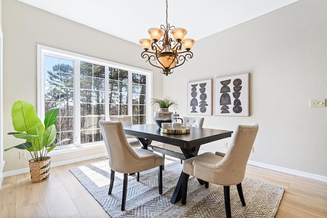 dining room with an inviting chandelier, light wood-style floors, and baseboards