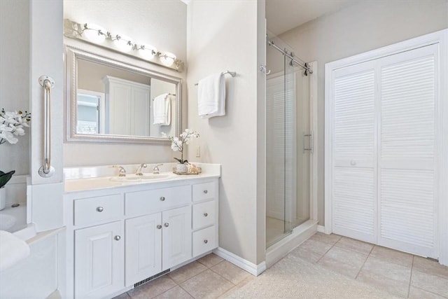 full bathroom with baseboards, vanity, a shower stall, and tile patterned flooring