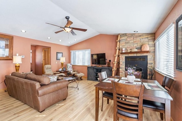 living area with a healthy amount of sunlight, a ceiling fan, lofted ceiling, and wood finished floors