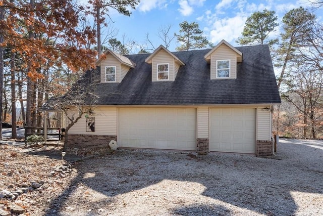 view of home's exterior with a garage, brick siding, and roof with shingles