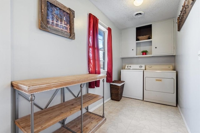 clothes washing area featuring visible vents, baseboards, cabinet space, a textured ceiling, and separate washer and dryer