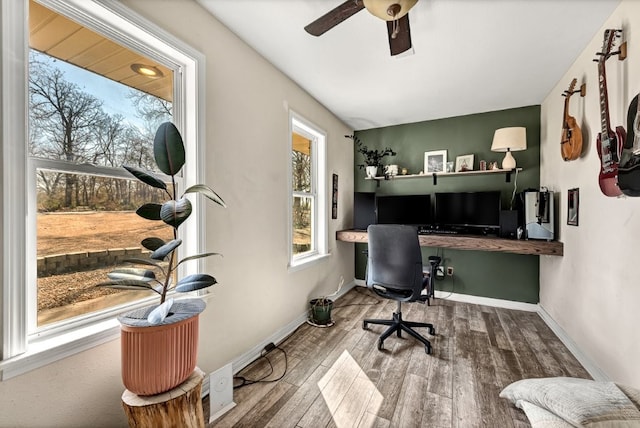 office featuring built in study area, a ceiling fan, baseboards, and wood finished floors