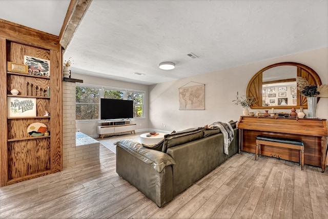 living area with visible vents and hardwood / wood-style floors