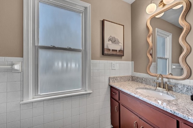 bathroom with tile walls, wainscoting, and vanity