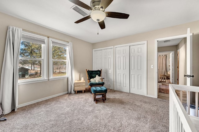 living area featuring visible vents, carpet flooring, and baseboards