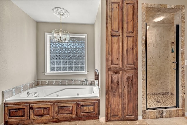 full bathroom featuring an inviting chandelier, a shower stall, and a jetted tub