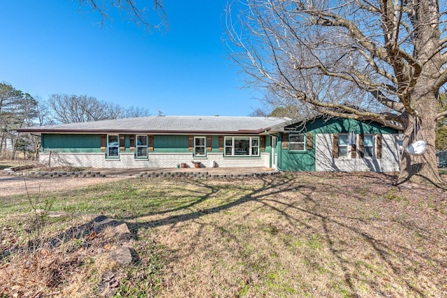 single story home featuring brick siding and a front lawn