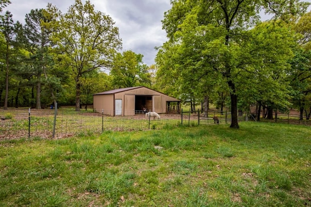 view of yard featuring an outbuilding, fence, and a detached garage