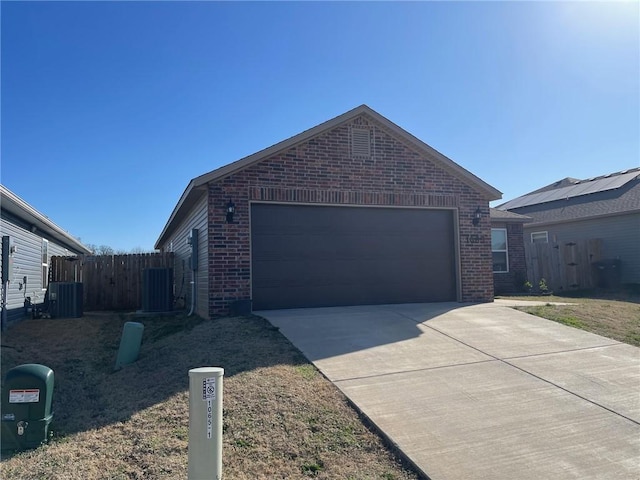 ranch-style home featuring concrete driveway, a garage, brick siding, and central AC