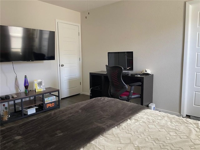 bedroom with baseboards and wood finished floors