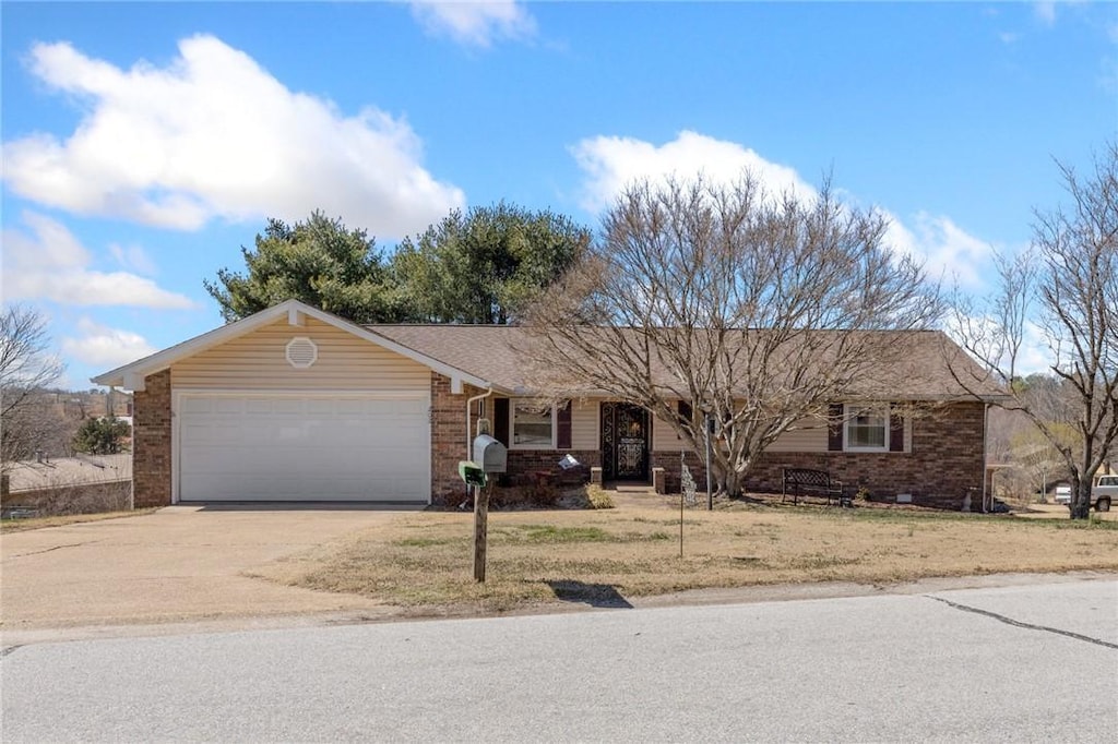 ranch-style home with concrete driveway, an attached garage, brick siding, and a front yard