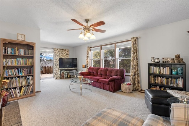 living room featuring a textured ceiling, carpet, and a ceiling fan