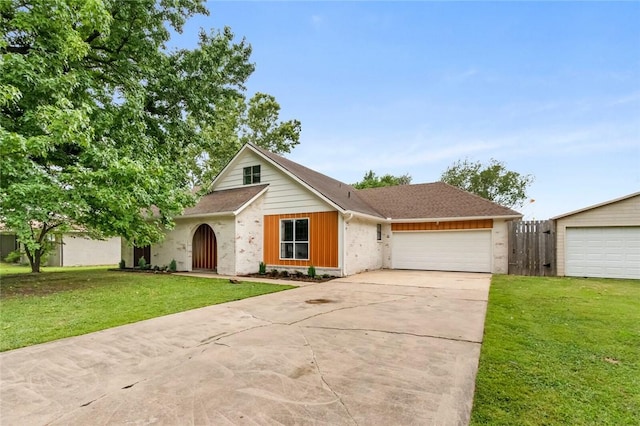 view of front of house featuring a front yard, an attached garage, fence, and driveway