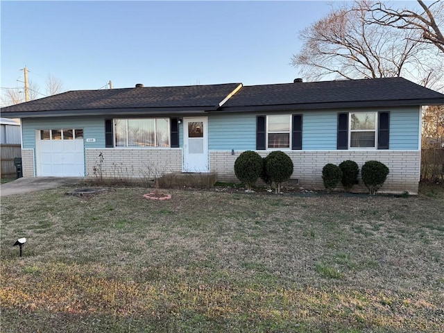 ranch-style house with brick siding, an attached garage, and a front lawn