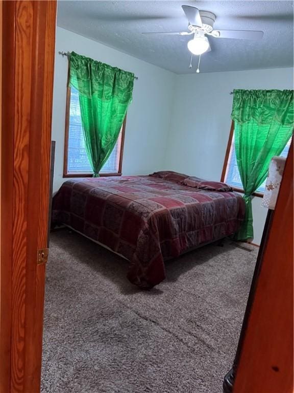 bedroom with a textured ceiling, ceiling fan, and carpet flooring