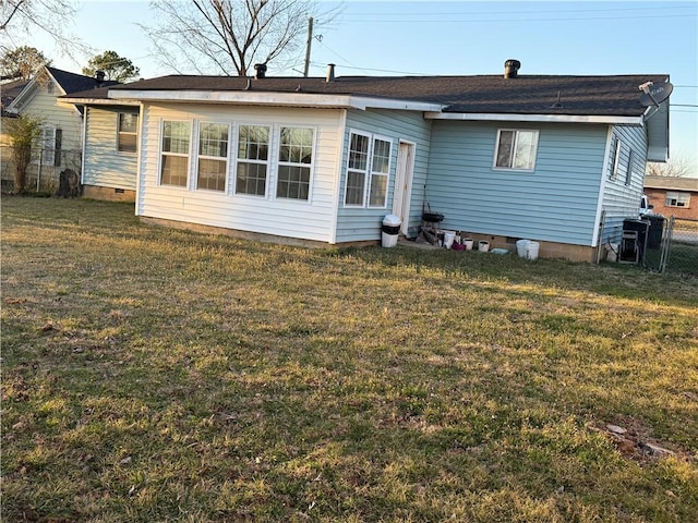 rear view of house featuring crawl space, a yard, and fence