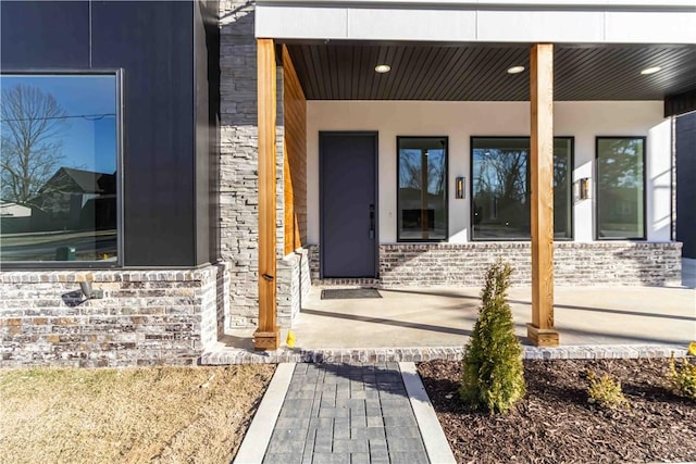 property entrance with stone siding and brick siding