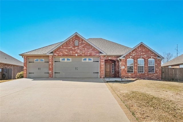 view of front of house featuring brick siding, concrete driveway, a front yard, and fence