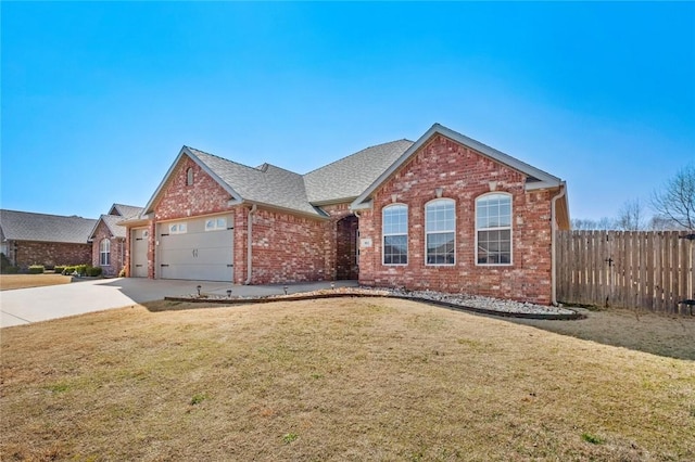 view of front of home with brick siding, a front lawn, fence, concrete driveway, and an attached garage