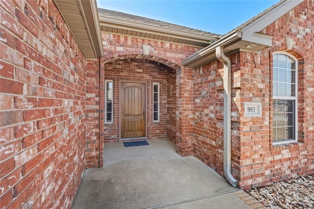 doorway to property with brick siding