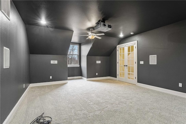 bonus room featuring baseboards, light colored carpet, lofted ceiling, and a ceiling fan