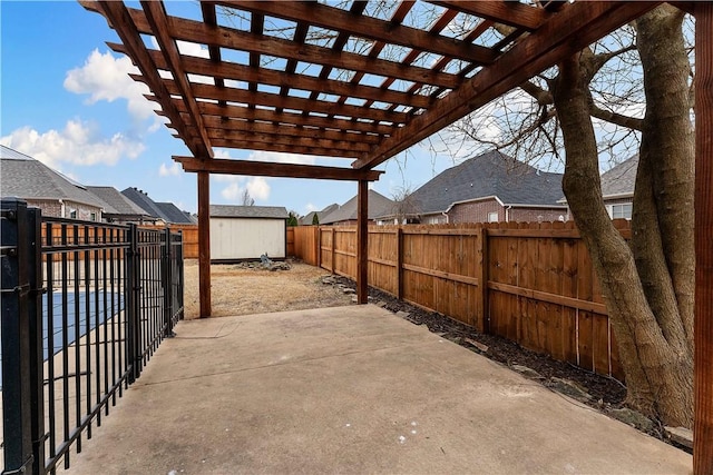 view of patio featuring a storage unit, an outbuilding, a fenced backyard, and a pergola