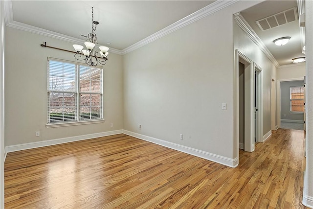 unfurnished room with visible vents, light wood-type flooring, baseboards, and ornamental molding