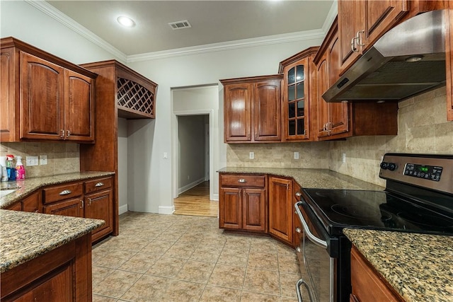 kitchen featuring electric range, under cabinet range hood, stone countertops, crown molding, and glass insert cabinets