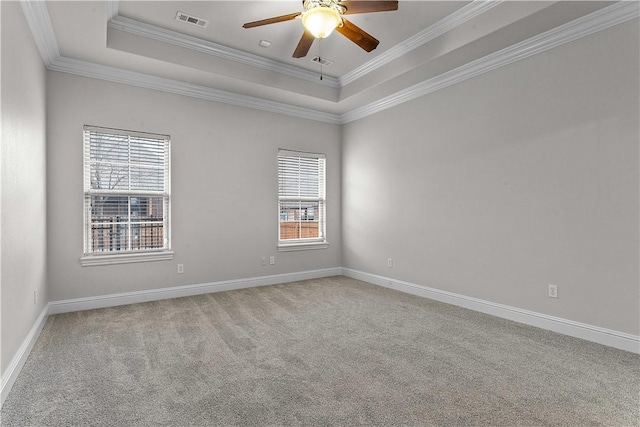 spare room with visible vents, a raised ceiling, carpet floors, and ornamental molding