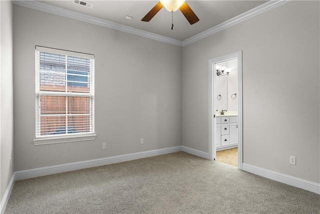 spare room featuring visible vents, ceiling fan, baseboards, light colored carpet, and ornamental molding